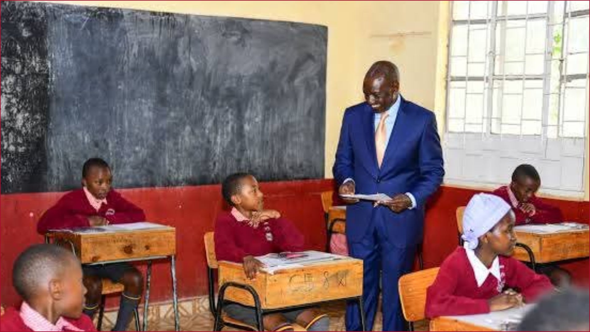 President William Ruto interacting with a primary school learner taking a national examination.